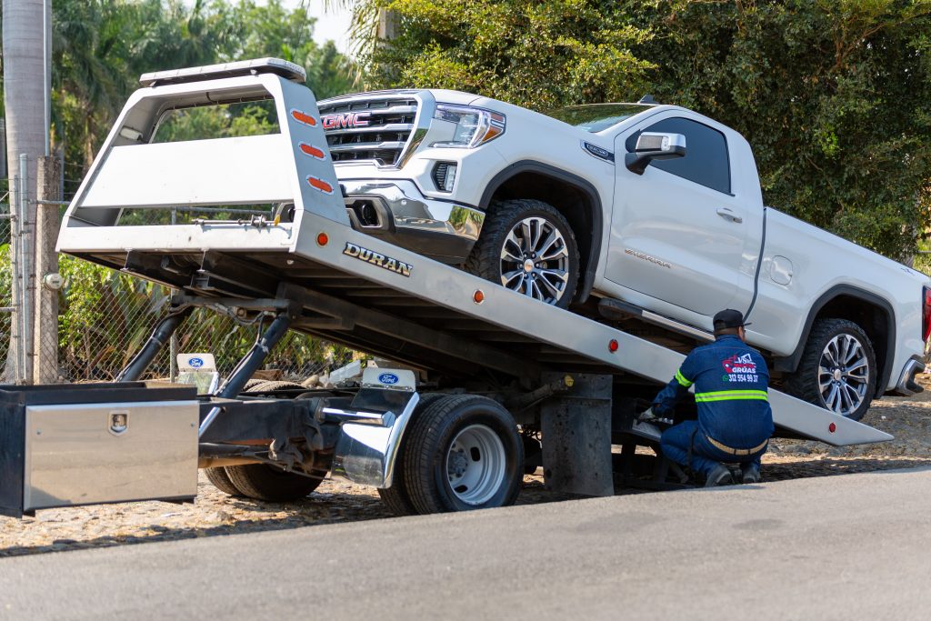 Affordable flatbed towing of a white pickup truck in Palm Coast, Florida