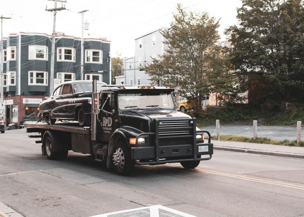 Black tow truck parked near buildings, reliable tow truck service in Palm Coast, Florida